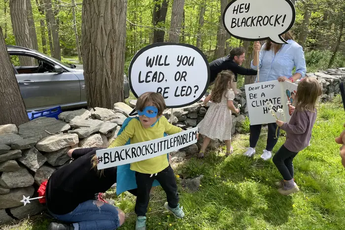 Sunrise Kids trying out signs before a climate protest in front of Larry Fink’s home, May 14th, 2022.